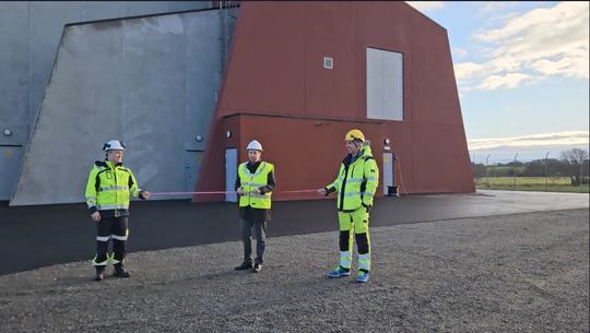 Ordfører Andreas Vollsund i Time kommune klipper snoren foran nye Håland transformatorstasjon bygget i grå og rød betong. Prosjektledere i gult synlighetstøy holder snoren. 