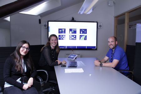 Tre ansatte i Lyse Elnett rundt et møtebord med stor skjerm i bakgrunnen. 